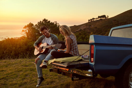 Sunset, truck or couple with guitar in nature on romantic holiday vacation for bonding or relaxing on date. Car road trip, travel or people playing music in summer with romance in park field together