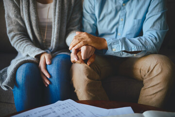 Holding hands, senior couple and life insurance support with paperwork in a living room. Home, anxiety and elderly people with empathy, stress and trust with solidarity for bills and tax problem - obrazy, fototapety, plakaty