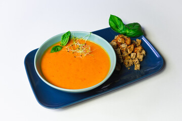Beautiful orange cream pumpkin soup served with croutons - white background