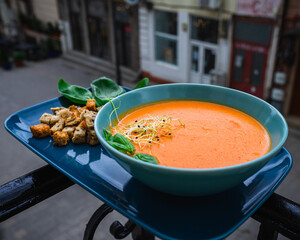 Top view- Beautiful orange cream pumpkin soup served with croutons - city backdrop
