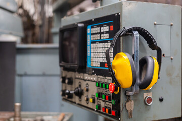 Soundproof headphones for industry plants hanging on lathe in factory. headphones protection...