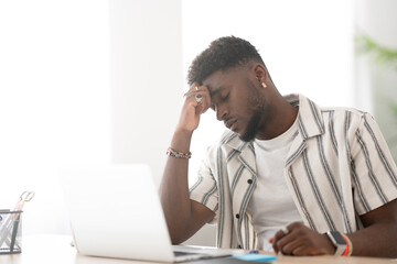 Frustrated black man in front of laptop