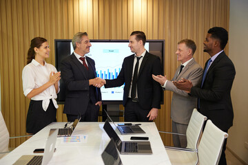 businesspeople shaking hands from success at work or project in conference room