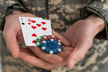 military man holding poker chips