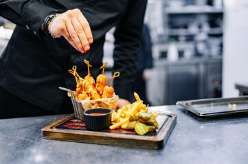 chef cookind corn dog with french fries on restaurant kitchen