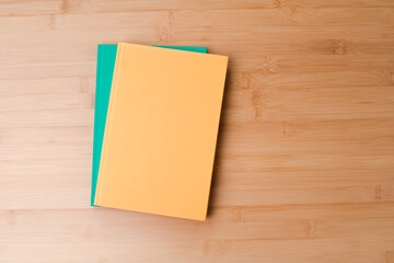 Template with stationery. Green and yellow notebooks on a wooden, bamboo background. Flat lay. Copy space