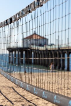 A beach volley net up close with the Manhattan Beach pier in the background in Los Angeles california USA on February 9th 2023