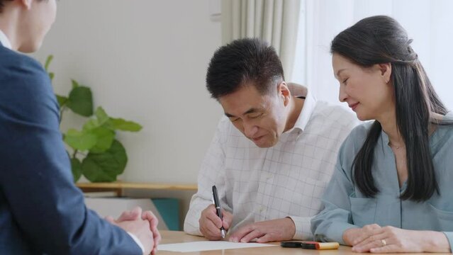 契約書にサインをするシニア夫婦