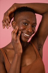 Obraz premium Portrait of smiling young woman against pink background