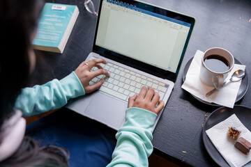 Female student using laptop while studying