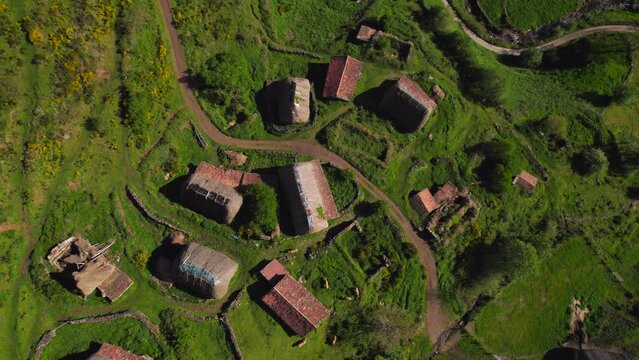 Aerial top down view of rural pornacal hamlet with many old straw huts at sunset time