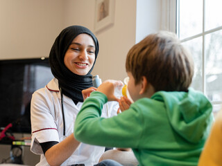 Doctor assisting boy using inhaler