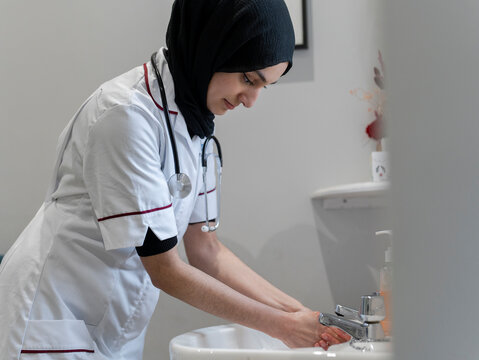 Doctor washing hands in sink