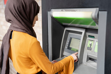Woman in hijab using ATM © Cultura Creative