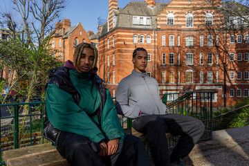 Portrait of young male friends sitting in park