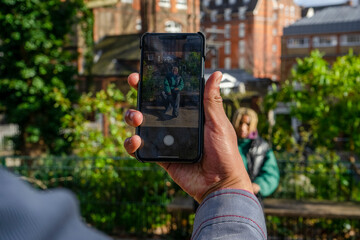 Man photographing friend with smart phone