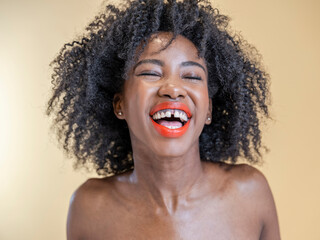 Studio portrait of woman laughing with eyes closed