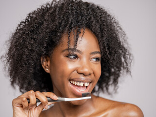 Studio portrait of smiling woman with toothbrush
