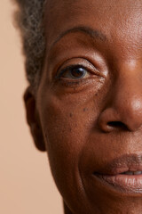 Close-up portrait of senior woman against beige background