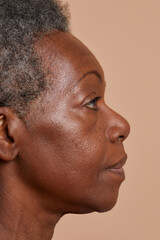 Profile view of senior woman against beige background