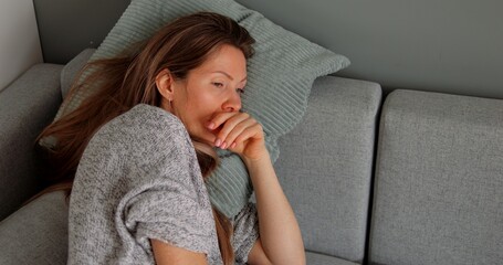 Thoughtful or confused disoriented middle age woman lie on sofa pillow. Concept of puzzled person...