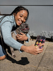 Woman taking selfie with dog on sunny day