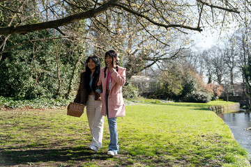 Fototapeta premium Young female friends walking in park