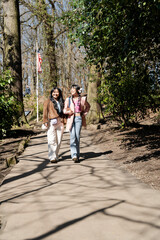 Fototapeta na wymiar Young female friends walking in park