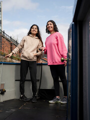 Two women standing on boat