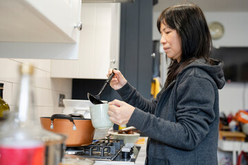 Woman pouring rice and ginger tea at home