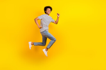 Fototapeta na wymiar Full length size photo of running fast speed energetic guy hurry up advertisement casual clothes sale isolated on yellow color background