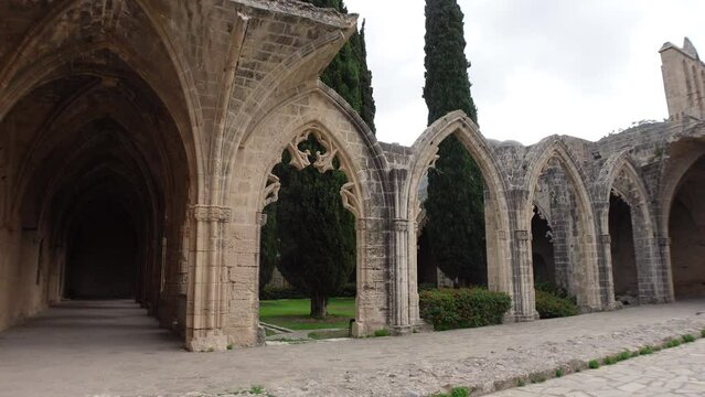 Steadicam shot walking past arches of historic Bellapais Monastery, a popular tourist destination in Northern Cyprus