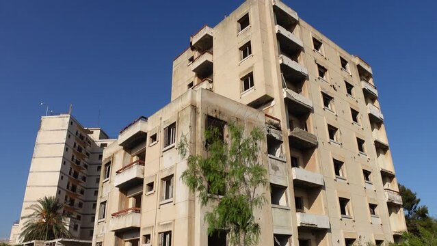Moving shot past damaged building with bullet holes in Varosha, a once thriving vacation and resort destination in Famagusta, Cyprus
