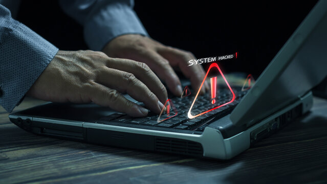 Businessman using  laptop with triangle caution warning , System warning hacked alertsign for notification error personal data hacking virus cybercrime.Compromised information concept.