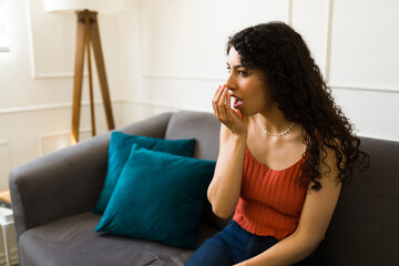 Ill young woman checking her bad breath suffering from halitosis