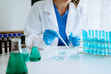 Modern medical research laboratory. female scientist working with micro pipettes analyzing biochemical samples, advanced science chemical laboratory