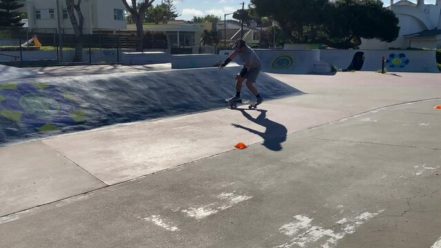Caucasian man skateboarding on the ramps on sunny day. Parque das gera&ccedil;&otilde;es, Estoril, Cascais, Europe.