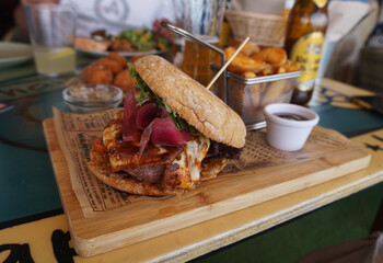 Freshly-made hamburger in the restaurant with a BBQ sauce close-up, selective focus 