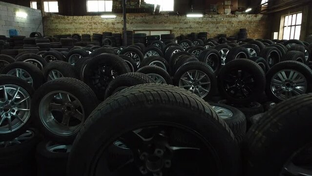 modern warehouse with stack of car tires with metal disk, auto repair service