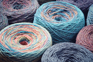 Round skeins of organic multi-coloured lambswool yarn.