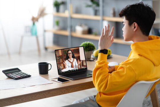 Asian boy studying at home, having video call with teacher - Powered by Adobe