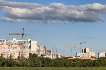 Naklejka premium cranes construction of apartment buildings landscape