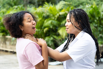 Angry African woman strangle her friend, concept of physical assault crime, quarrel or fighting among friend with violence