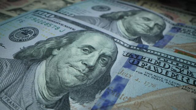 Macro shot of a new 100 dollar bill. 100 Dollar bills print. Inflation and deflation concept. Money making machine. Loop of banknotes being made. Machine printing Benjamin Franklin banknotes.