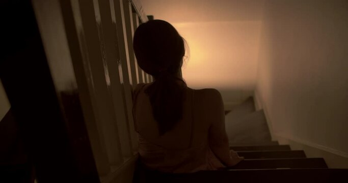 A lonely woman is sitting on the stairs at night . This concept use for symptoms of stress, major depressive disorder (MDD), psychotic symptoms. 