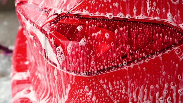 Closeup of rear car brake lamp of a red car being washed
