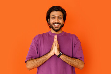 Happy positive handsome indian guy showing namaste gesture - obrazy, fototapety, plakaty