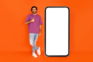 Cheerful eastern man recommending nice mobile app, mockup