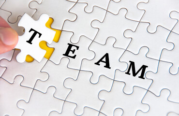 Team text on white jigsaw puzzle. Business and teamwork concept