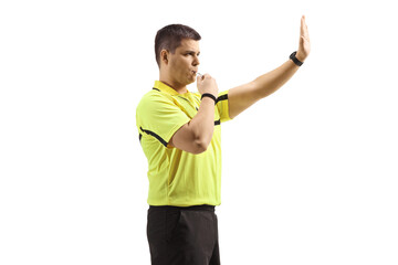 Football referee blowing a whistle and gesturing stop